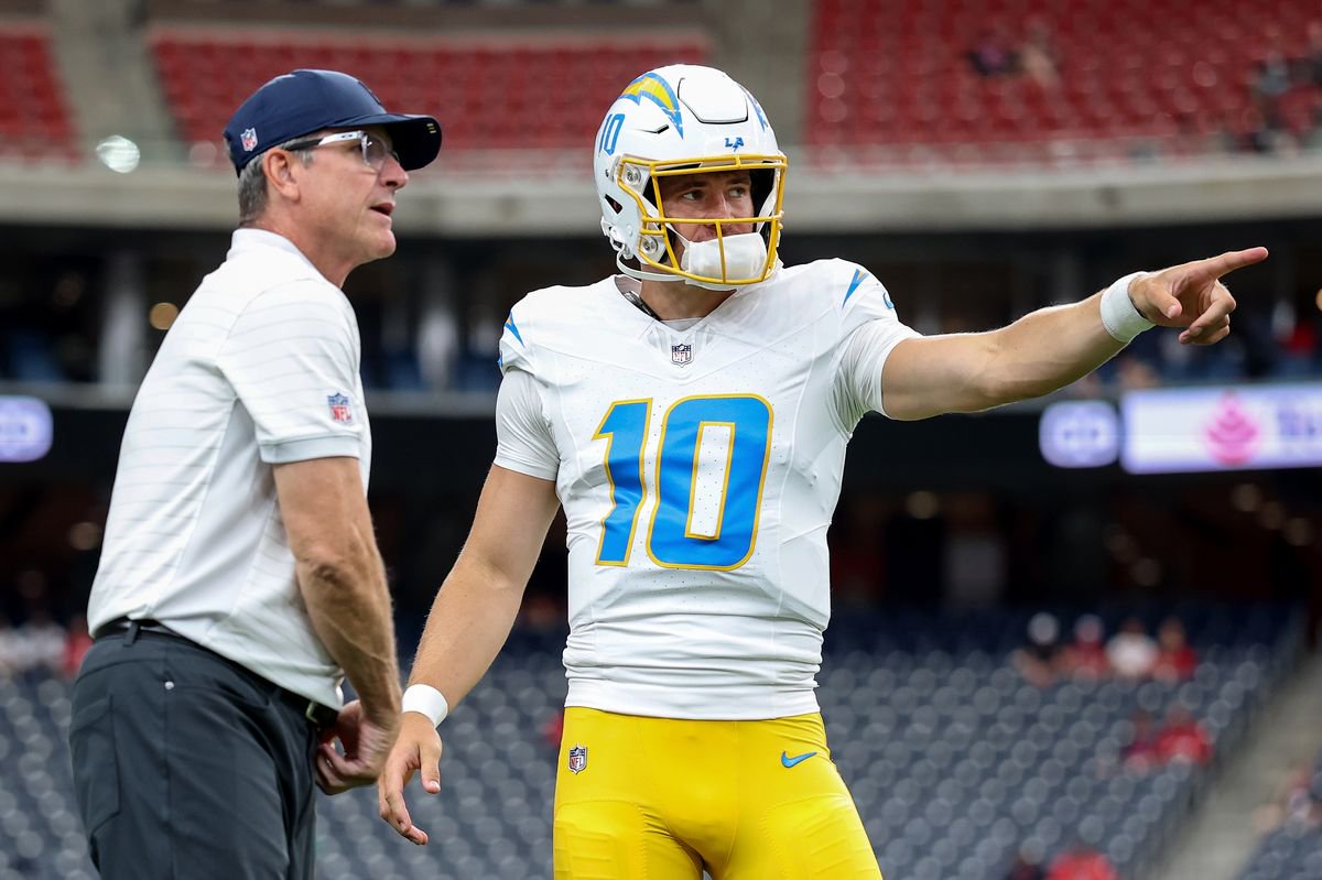 Justin Herbert #10 of the Los Angeles Chargers talks with head coach Jim Harbaugh