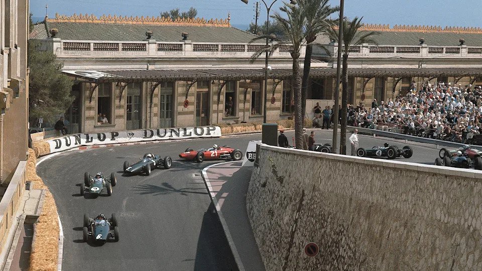 Graham Hill leads Jim Clark in the early stages of the 1963 Monaco Grand Prix, as a train of cars come through the hairpin
