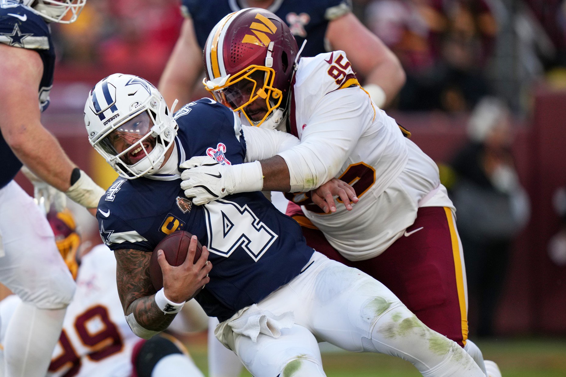 Dallas Cowboys quarterback Dak Prescott (4) is sacked by Washington Commanders defensive tackle Jer'zhan Newton (95) during the second half an NFL football game Thursday, Dec. 25, 2025, in Landover, Md. (AP Photo/Stephanie Scarbrough)