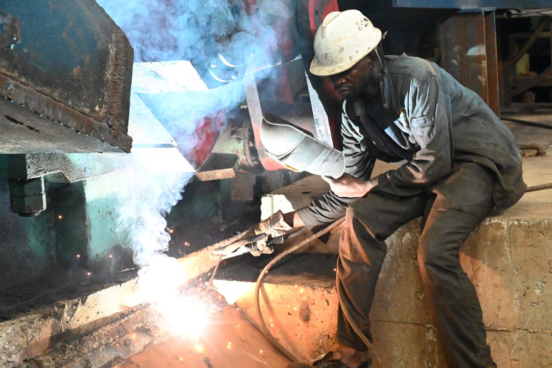 A welder at Sino Uganda's UNISTEEL, where "zero compromise" safety includes full PPE.