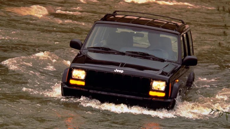 1997 Jeep Cherokee wading through river with water at tire-height