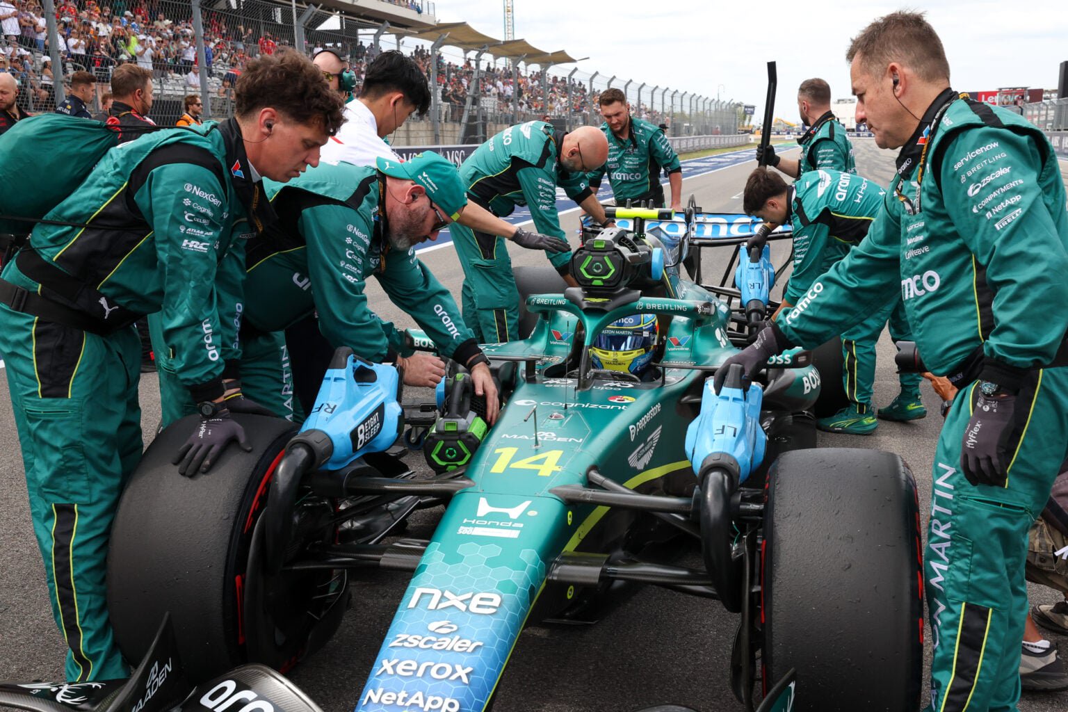 Aston Martin mechanics work on Fernando Alonso's car on the 2026 F1 United States Grand Prix grid
