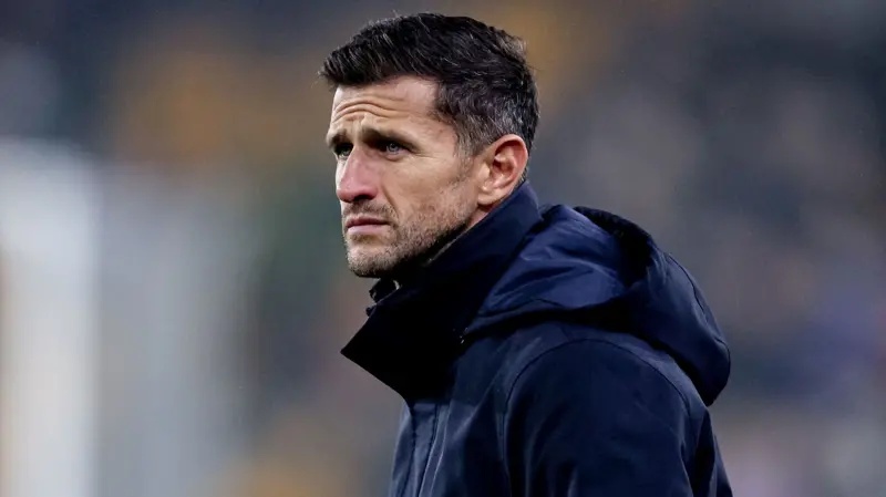 John Mousinho wearing a navy blue jacket on the sideline at Molineux during Portsmouth's 1-1 draw with Wolves