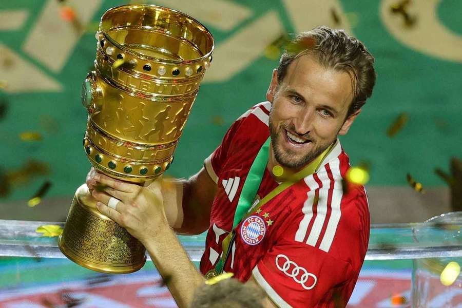 Bayern Munich's Harry Kane carries the trophy as he celebrates winning the DFB Cup
