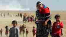 Reuters Woman with children fleeing Sinjar after IS attack in 2014
