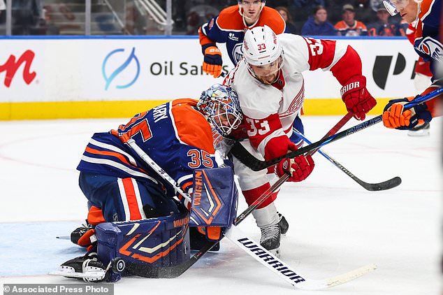 Edmonton Oilers goaltender Tristan Jarry (35) battles against Detroit Red Wings' Viktor Arvidsson (33) during third period NHL hockey action in Edmonton, Alberta, Monday, Oct. 26, 2026. (Codie McLachlan/The Canadian Press via AP)