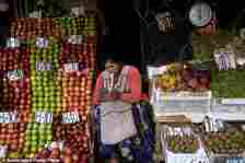 A vendor waits for customers at her produce stand, a day after Army troops stormed the government palace in what President Luis Arce called a coup attempt, in La Paz, Bolivia, Thursday, June 27, 2024. (AP Photo/Carlos Sanchez)