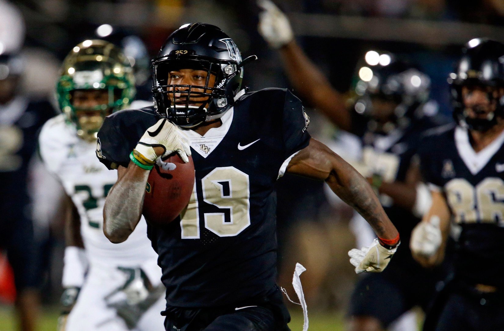 UCF Knights kick returner Mike Hughes (19) runs back the kick 94 yards for the go-ahead score against the South Florida Bulls during the second half at Spectrum Stadium.