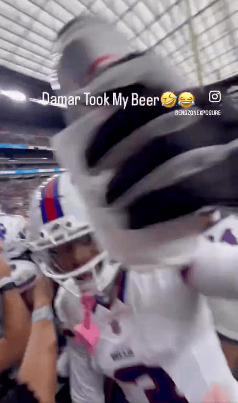 A close-up, blurry shot of a football player in a white uniform extending his gloved hand toward the camera, with the caption "Damar Took My Beer 🤣😂" at the top.