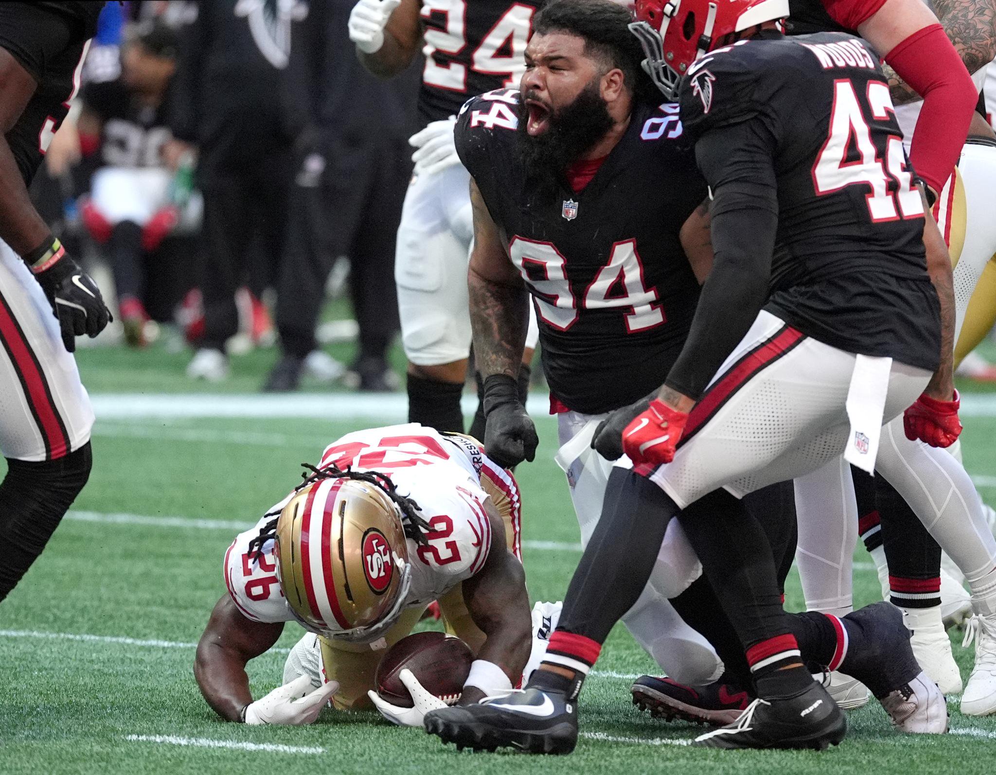 Atlanta Falcons defensive lineman LaCale London (94) celebrates after tackling San Francisco 49ers running back Kaelon Black (26), who has lost his helmet.