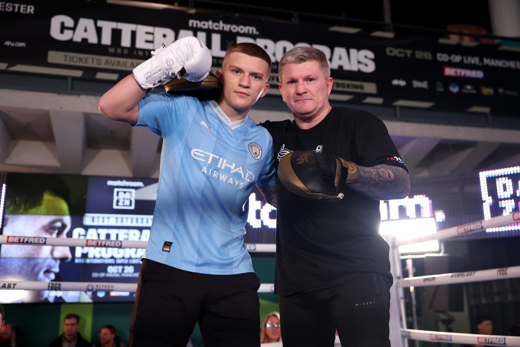 Jack Catterall posing with a trainer during a public workout in front of a Matchroom banner.