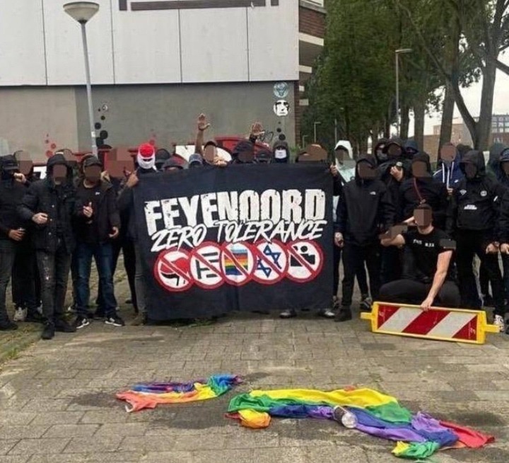 Feyenoord Ultras hold up their "Zero Tolerance" banner while posing with flags they stole from Celtic supporters in Rotterdam