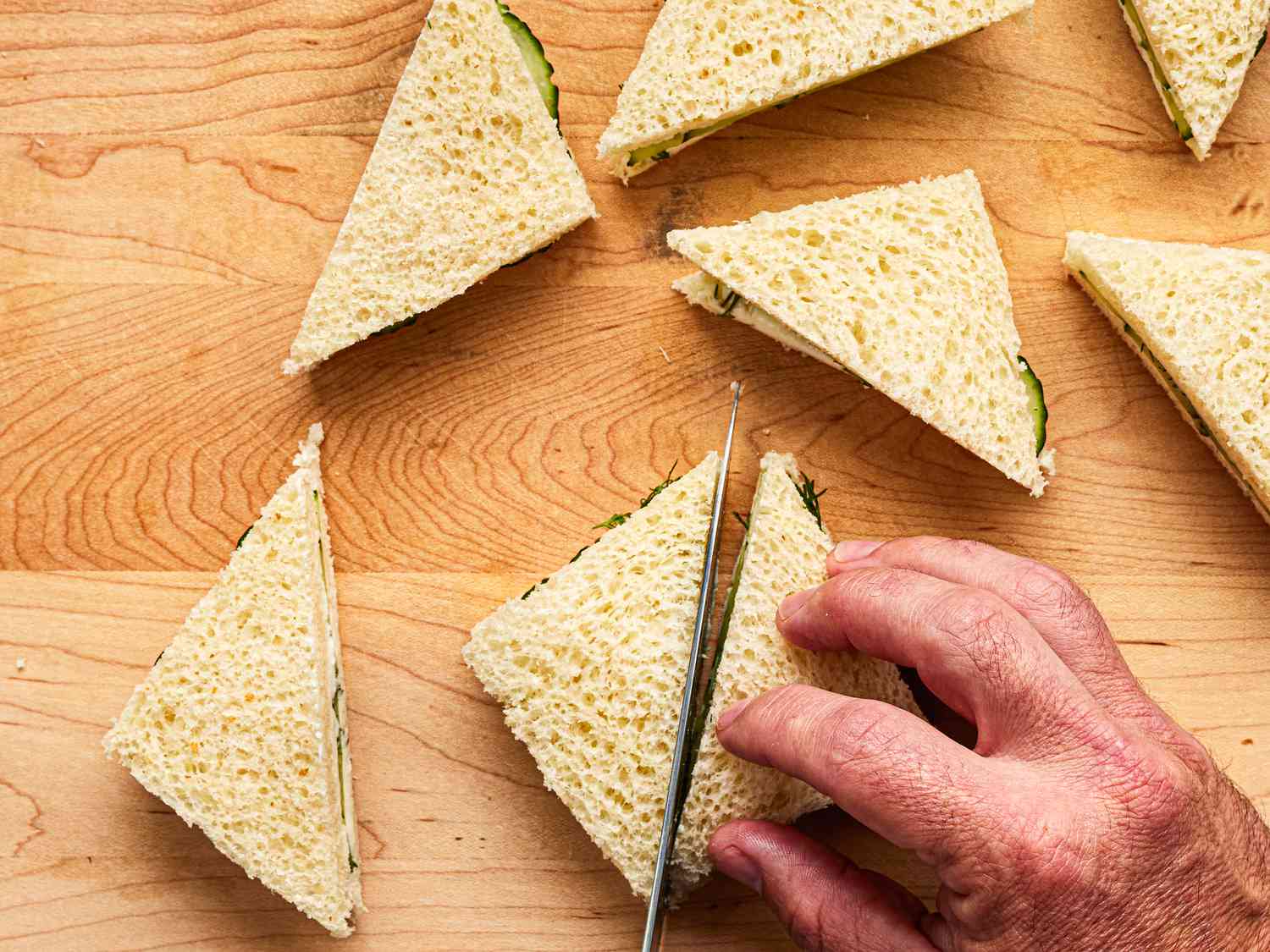 Overhead view of cutting sandwiches into triangles