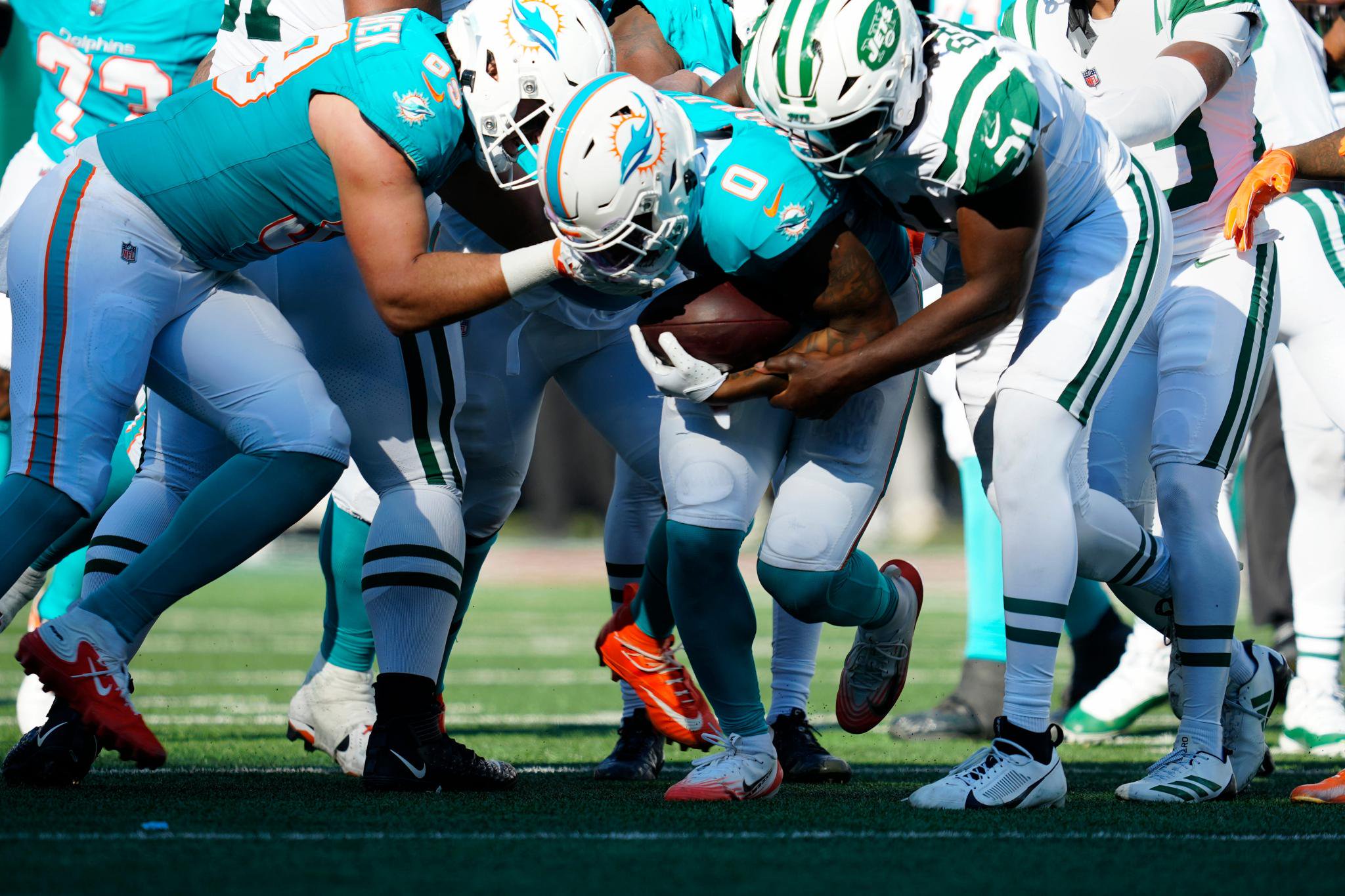 Miami Dolphins running back Ollie Gordon II (0) holds onto the ball near the end zone.