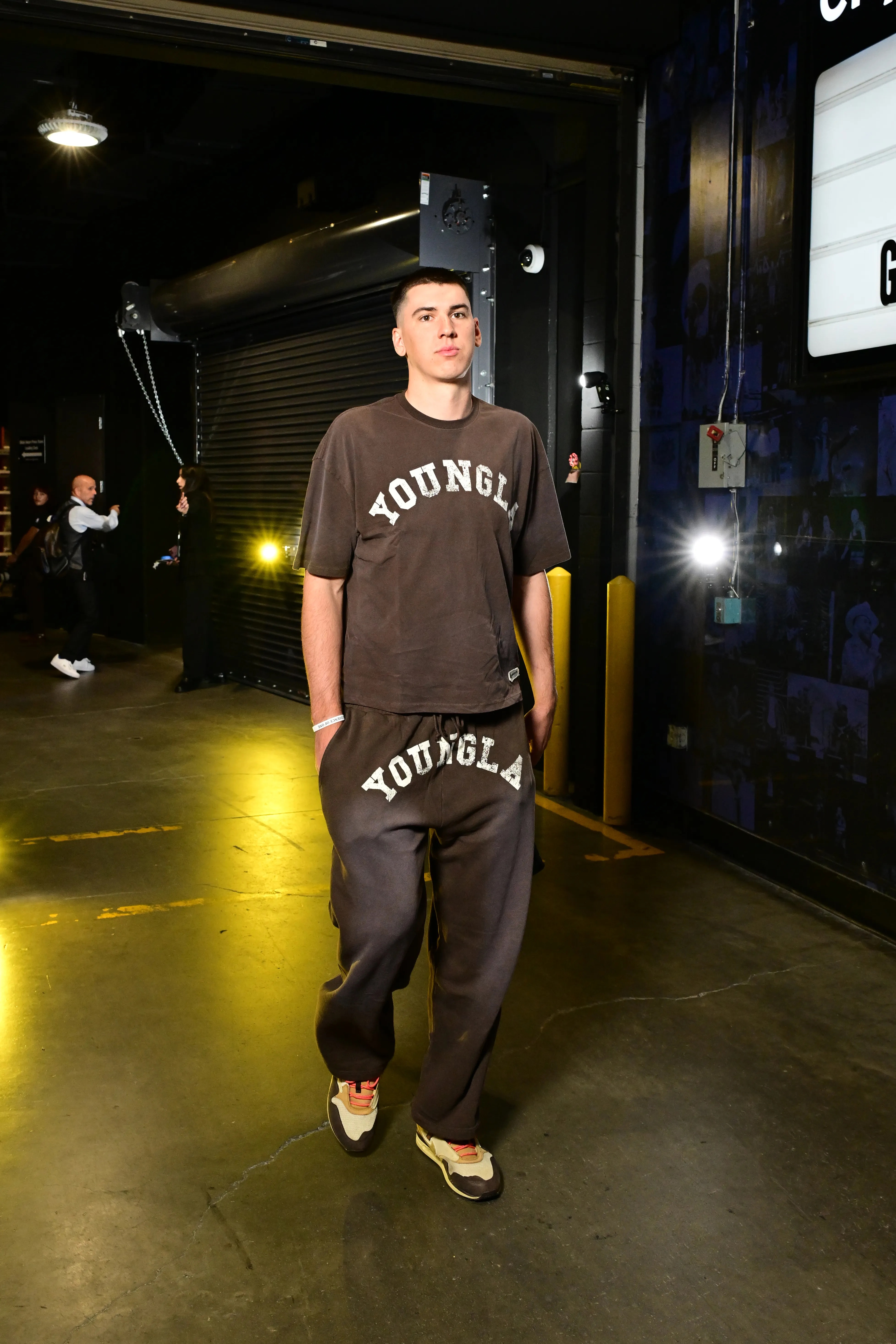 Jake LaRavia of the Los Angeles Lakers arrives at the arena wearing a brown t-shirt and matching sweatpants.