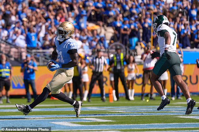 UCLA running back Jaivian Thomas, left, runs in for a touchdown as Michigan State safety Michael Richard defends during the first half of an NCAA college football game , Saturday, Oct. 24, 2026, in Pasadena, Calif. (AP Photo/Mark J. Terrill)