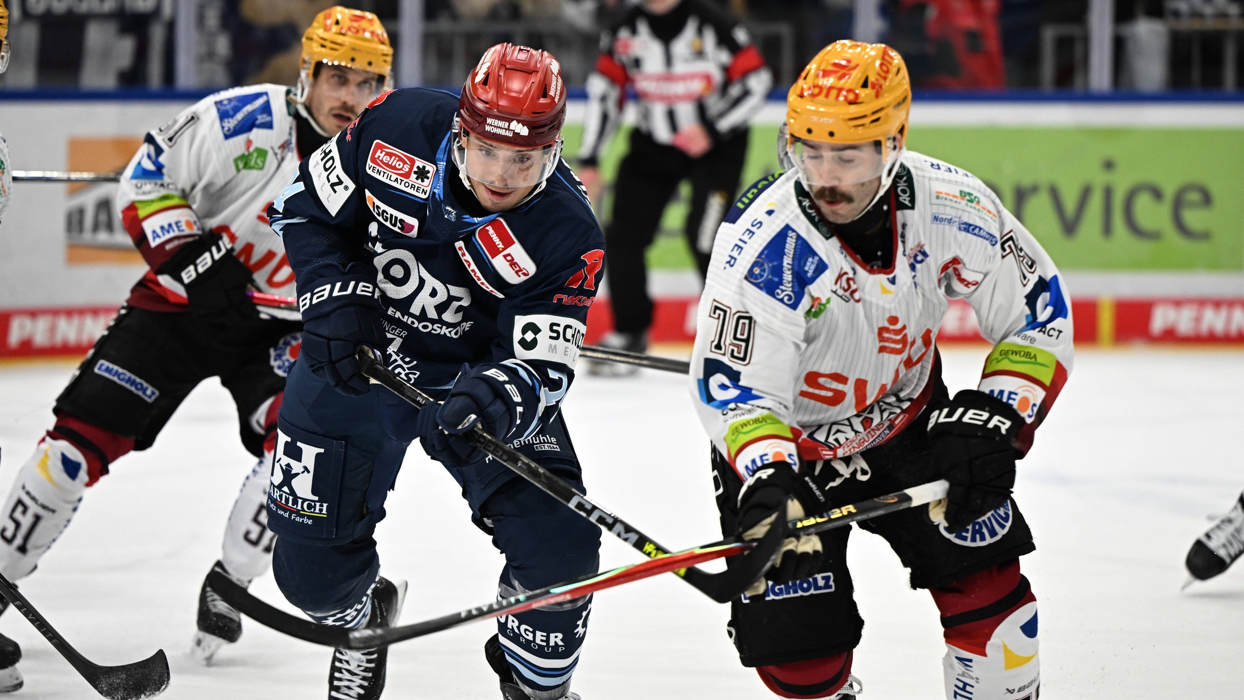 Eishockey-Spieler der Fischtown Pinguins und der Schwenninger Wild Wings sind im Zweikampf auf dem Eis.