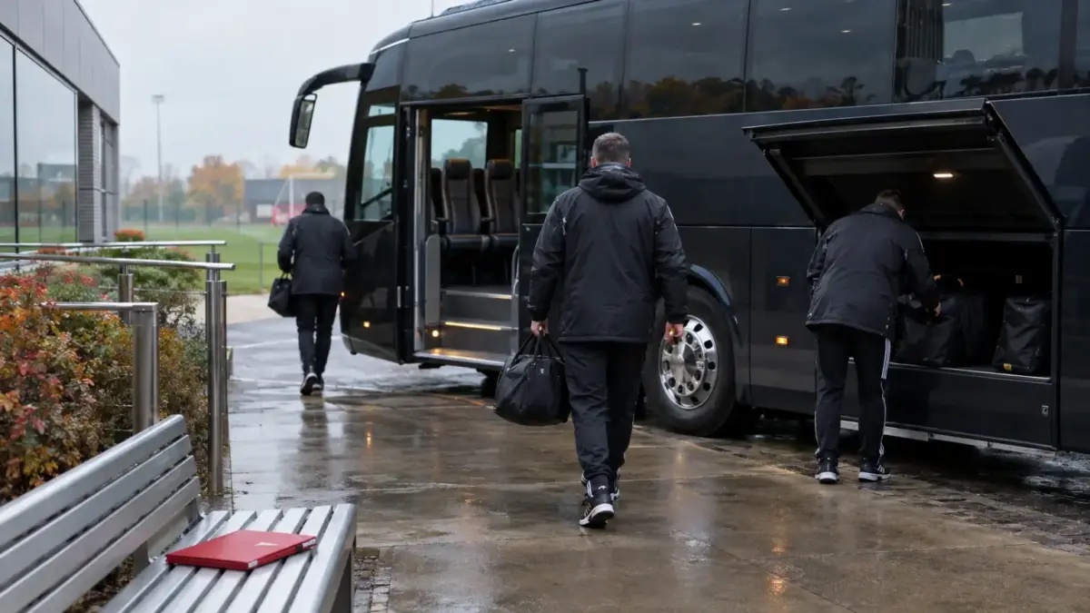 Unbranded football team coach with empty seats and equipment bags at a training-ground departure area
