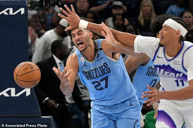 Memphis Grizzlies forward Cameron Boozer (27) and Utah Jazz center Jaxson Hayes (11) struggle for control of the ball in the second half of an NBA basketball game Wednesday, Oct. 21, 2026, in Memphis, Tenn. (AP Photo/Brandon Dill)