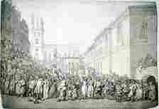 A public execution at Newgate, London, late 18th century. In the centre of the picture three people have been hanged. The picture is crammed full of people who have turned up to watch. They even hang out of the windows, and are on the roof of, the building on the left. On the far right a street seller takes advantage of the crowds and is selling his wares from a basket. In the very centre foreground a woman sits on a man's shoulders in order to get a better look. (Photo by Museum of London/Heritage Images/Getty Images)