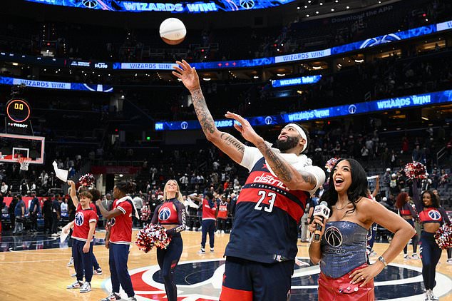 Washington Wizards forward/center Anthony Davis (23) throws out a mini basketball to the crowd after an NBA basketball game against the Milwaukee Bucks, Wednesday, Oct. 21, 2026, in Washington. (AP Photo/Nick Wass)