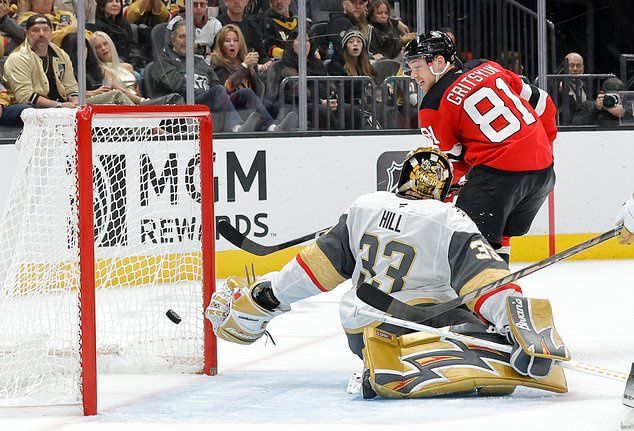 New Jersey Devils right wing Arseny Gritsyuk (81) scores against Vegas Golden Knights goaltender Adin Hill (33) during the second period of an NHL hockey game Friday, Oct. 30, 2026, in Las Vegas. (Steve Marcus/Las Vegas Sun via AP)