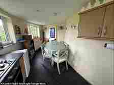 Auctioneers say the property is ideal for those looking for a quiet place to live. Pictured: The kitchen and dining area
