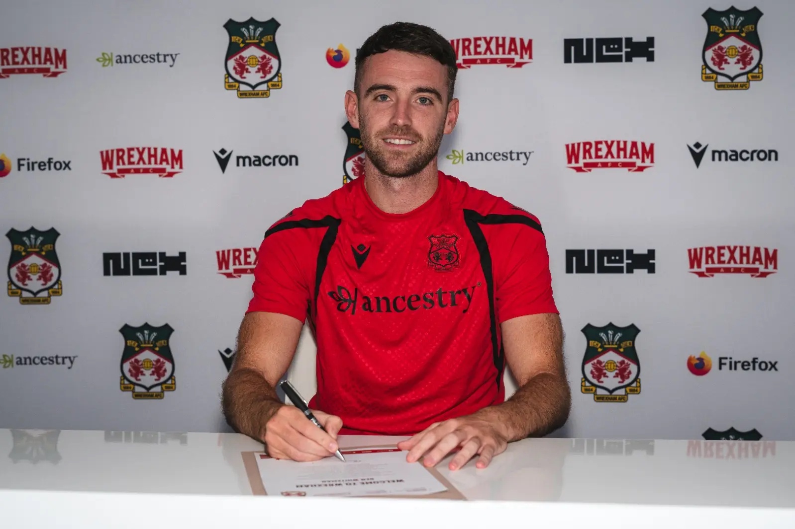 Ben Whiteman poses with his Wrexham contract.