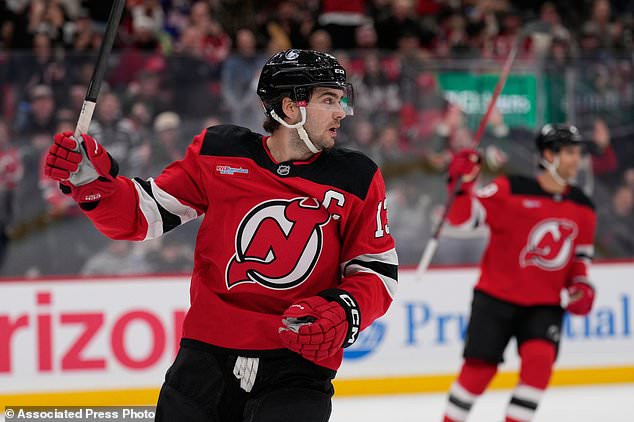 New Jersey Devils' Nico Hischier celebrates a goal by teammate Declan Chisholm during the second period of an NHL hockey game against the Colorado Avalanche in Newark, N.J., Tuesday, Oct. 20, 2026. (AP Photo/Seth Wenig)