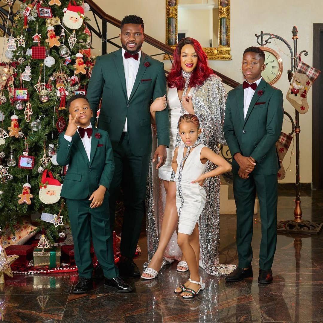 Former Super Eagles captain Joseph Yobo poses with his family in festive outfits beside a decorated Christmas tree