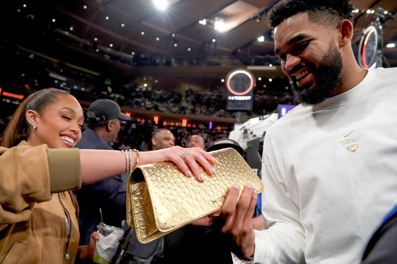 Jordyn Woods and husband Karl-Anthony Towns hold her new ‘Trophy Gold’ clutch on Oct. 20.Credit: Sarah Stier/Getty