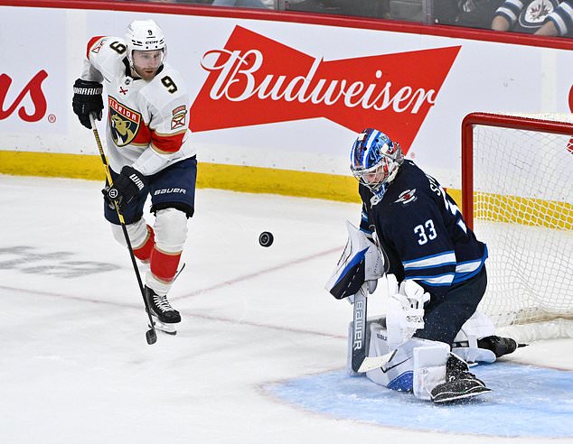 Winnipeg Jets goaltender Clay Stevenson (33) makes a save on Florida Panthers' Sam Bennett (9) during third period NHL action in Winnipeg on Tuesday, Oct. 27, 2026. (Fred Greenslade/The Canadian Press via AP)
