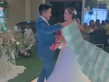 A groom presents his bride with a money cape