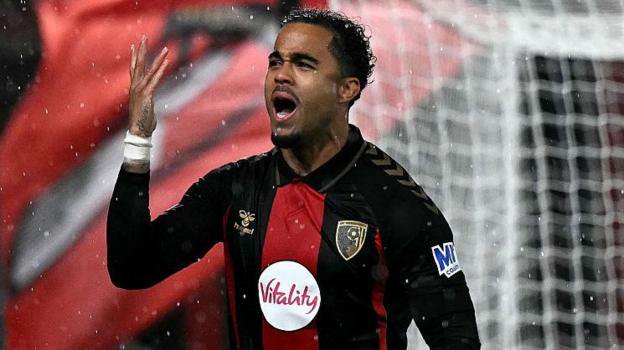 Justin Kluivert throws arm in the air as the rain comes down after scoring against AC Milan