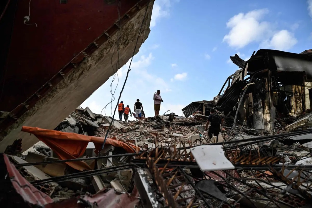 Rescuers search for possible victims at a collapsed building following twin earthquakes, in Caraballeda, La Guaira State, some 40 km northeast of Caracas, on June 27, 2026. The death toll in Venezuela's June 24 twin earthquake disaster reached 1,430, and millions more were feared to lack sanitation and other basic needs, as the first US aid flights landed in Caracas. (Photo by Maryorin Mendez / AFP)