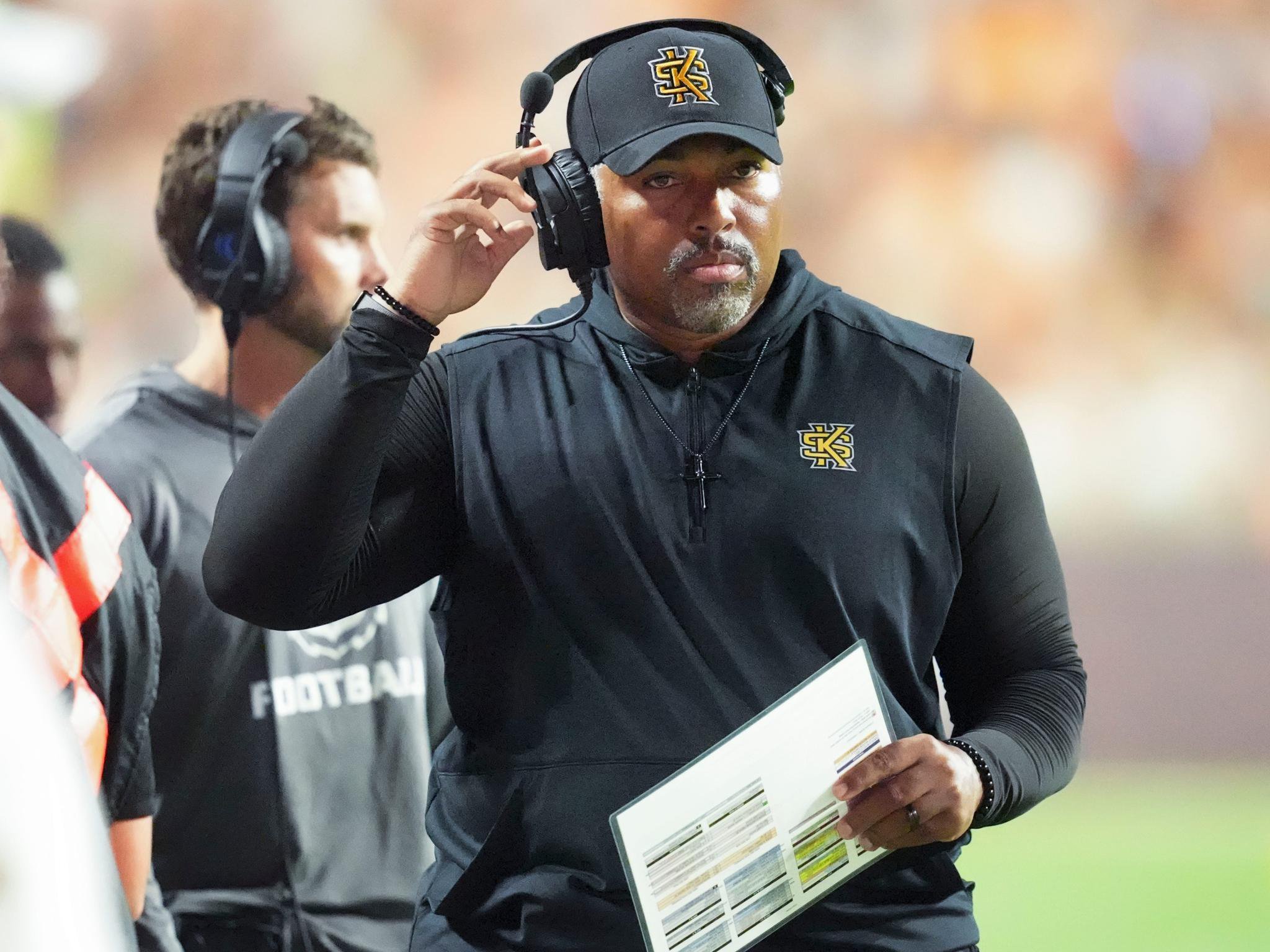 Kennesaw State coach Jerry Mack wears a headset on the sideline during a game.