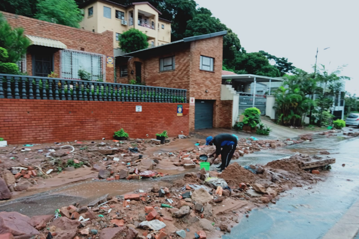 A resident clears rubble after a mudslide in Lotus Road, Springfield, in the early hours of Tuesday morning. Standard Bank has donated R2m to two NGOs working to support flood-affected communities in the province.