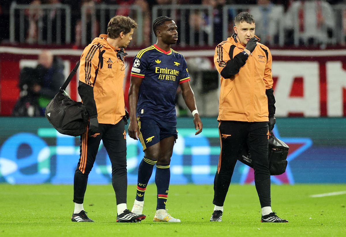 MUNICH, GERMANY - OCTOBER 21: Bukayo Saka of Arsenal receives medical attention after sustaining an injury during the UEFA Champions League 2026/27 League Phase MD3 match between FC Bayern München and Arsenal FC at Football Arena Munich on October 21, 2026 in Munich, Germany. (Photo by Alex Grimm/Getty Images)