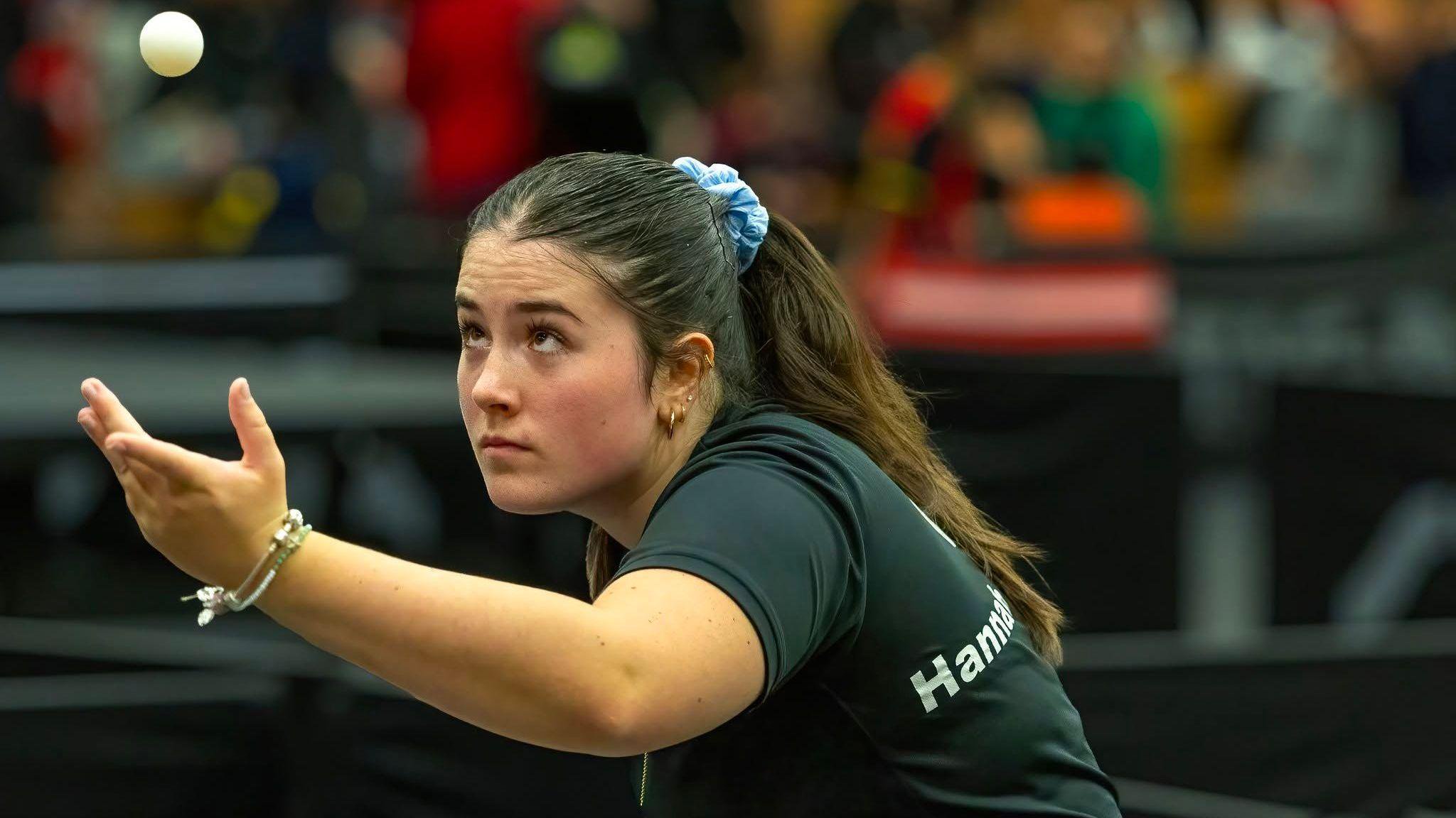 A picture of table tennis player Hannah Silcock, who had previously benefited from the programme playing the sport. She has thrown a ball up in the air 
