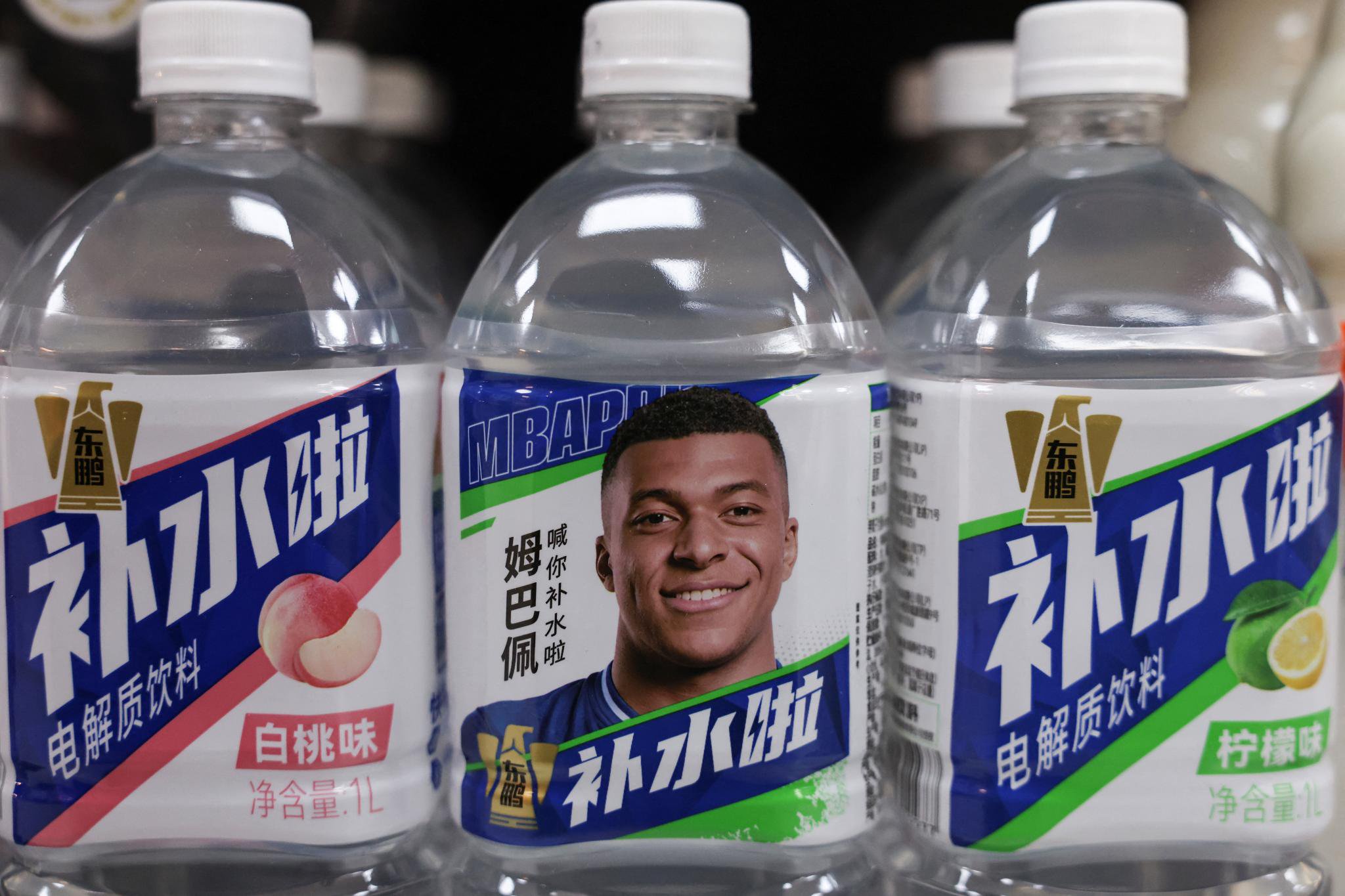 Bottled drinks by Eastroc Beverage featuring French soccer player Kylian Mbappe are displayed on a store shelf in Beijing.
