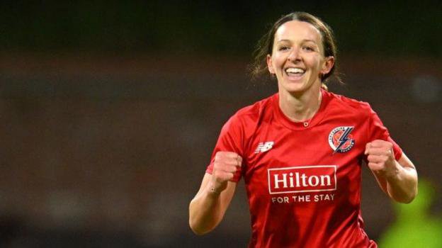 Kate Cross celebrates taking a wicket for Lancashire, wearing red kit