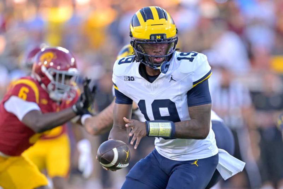 Michigan Wolverines quarterback Bryce Underwood (19) hands off the ball in the first half against the USC Trojans at United Airlines Field at the Los Angeles Memorial Coliseum. © Imagn