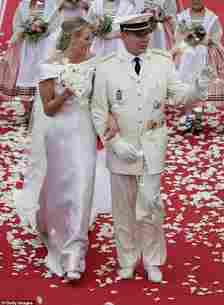 Charlene and Prince Albert beam as they walk arm in arm after the religious ceremony at their 2011 wedding