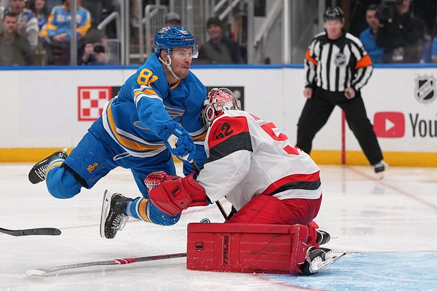 St. Louis Blues' Dylan Holloway (81) collides with Carolina Hurricanes goaltender Pyotr Kochetkov (52) during the second period of an NHL hockey game Saturday, Oct. 24, 2026, in St. Louis. (AP Photo/Jeff Roberson)