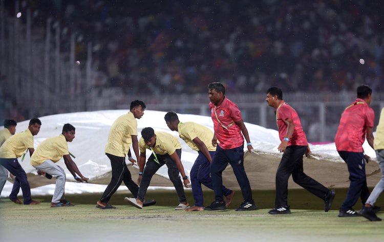 Groundstaff at the Eden Gardens stadium in Kolkata work together to pull in the covers during the KKR vs PBKS match in IPL 2025. (Image: Reuters)