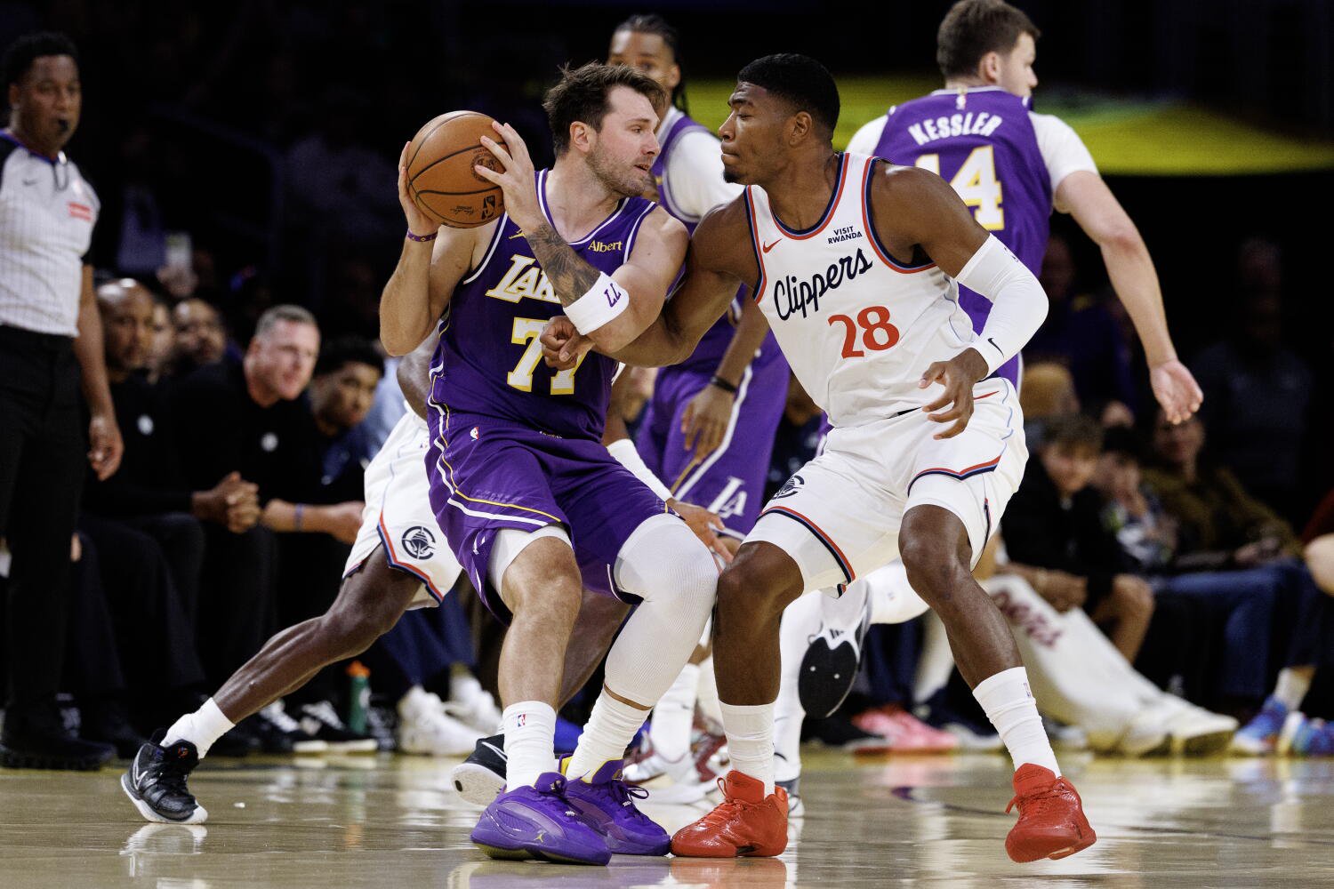 Clippers forward Rui Hachimura, right, plays tight defense on Lakers guard Luka Doncic, who uses his body to protect the ball