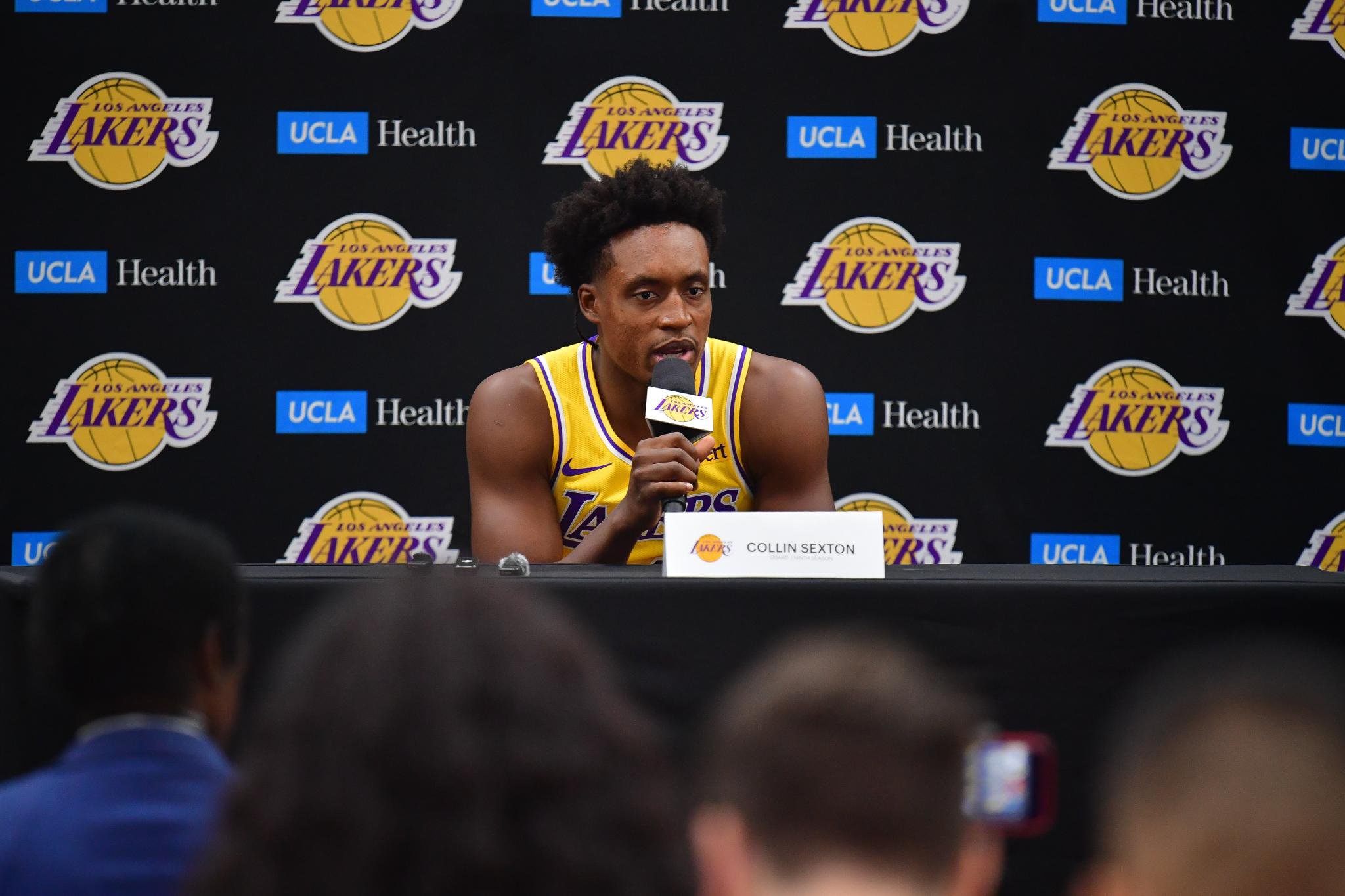 Collin Sexton speaks at a podium during a Los Angeles Lakers media day.