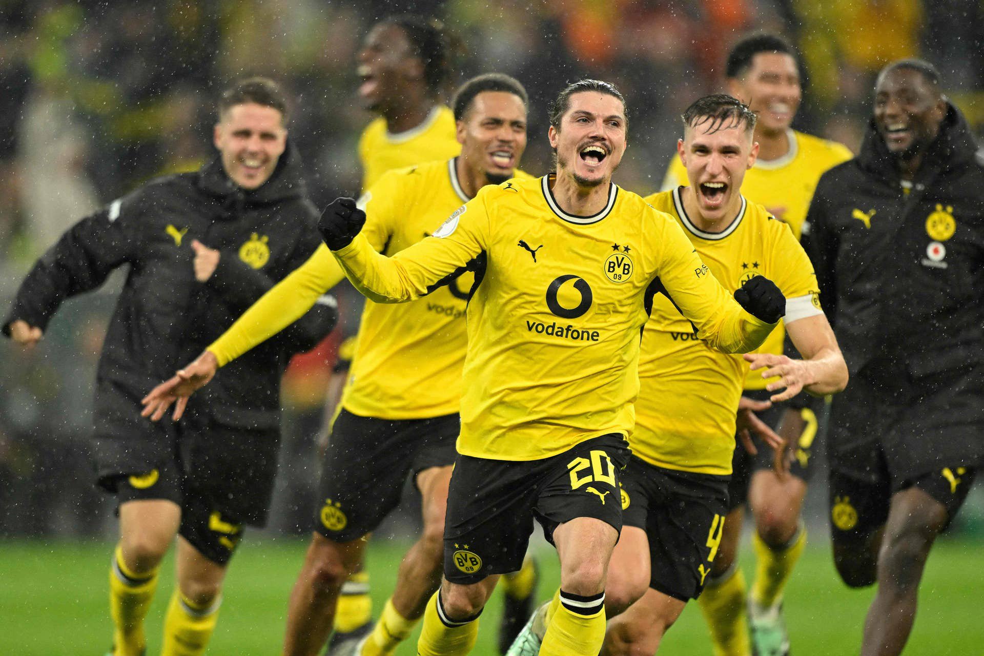 Borussia Dortmund-Spieler jubeln im Regen nach einem Torerfolg im DFB-Pokalspiel.