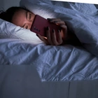 Scrolling on Your Phone in Bed Could Make Your Melatonin Supplements Less Effective, According to Sleep Doctors
