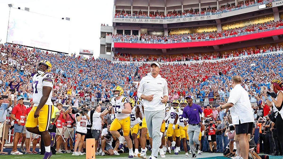 Lane Kiffin enters the field before a game at Vaught-Hemingway Stadium.